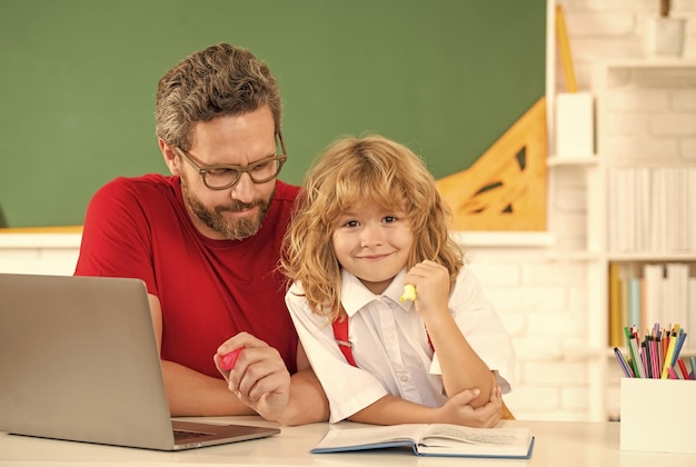 Vater und Sohn lernen im Klassenzimmer mit Laptop-Schule