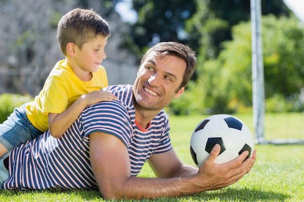 Vater und Sohn liegen auf Gras im Park