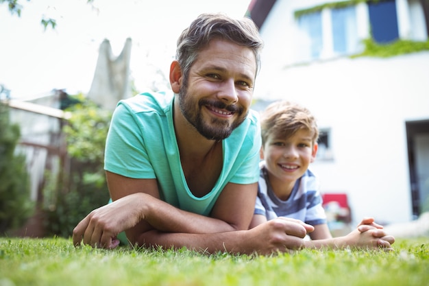 Vater und Sohn liegen auf Gras