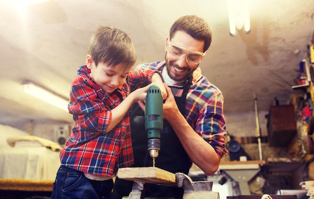 Vater und Sohn mit Bohrer arbeiten in der Werkstatt