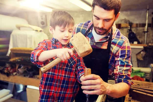 Vater und Sohn mit Meißel in der Werkstatt