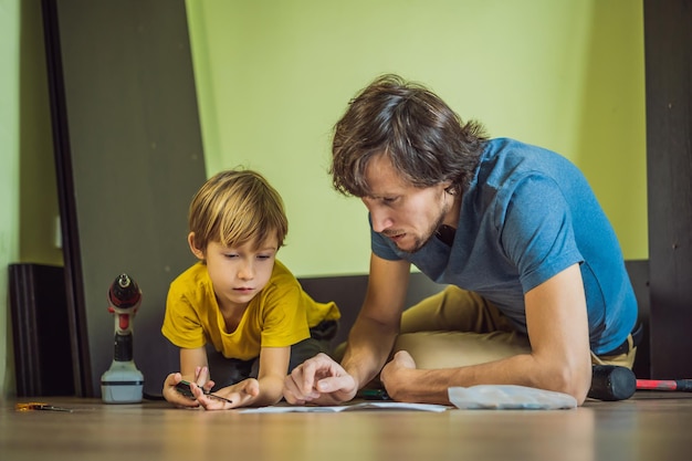 Vater und Sohn montieren Möbel Junge hilft seinem Vater zu Hause Happy Family Konzept