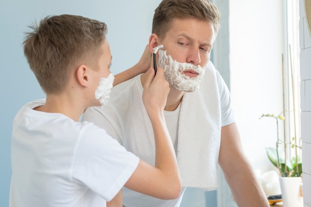 Vater und Sohn rasieren sich im Badezimmer