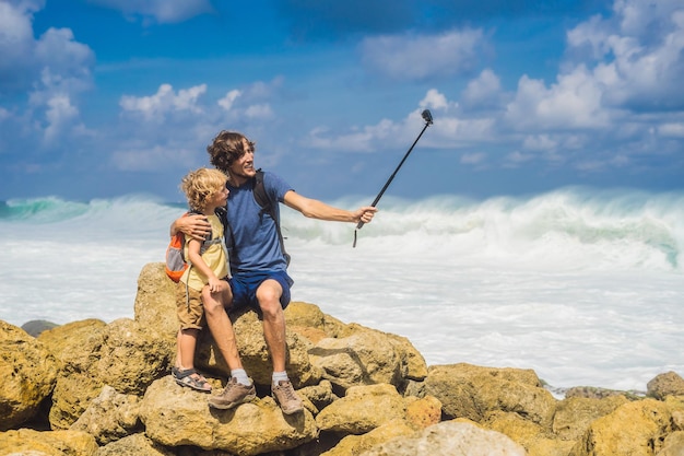 Vater und Sohn Reisende am fantastischen Melasti Beach mit türkisfarbenem Wasser Insel Bali Indonesien Reisen mit Kinderkonzept