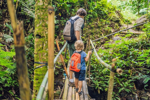 Vater und Sohn Reisende auf der Hängebrücke in Bali. Reisen mit Kinderkonzept.