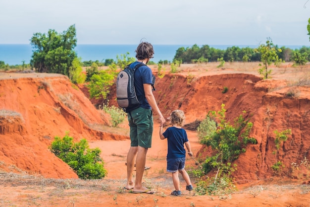 Vater und Sohn Reisende in der roten Schlucht nahe Mui Ne, Südvietnam. Reisen mit Kindern Konzept.