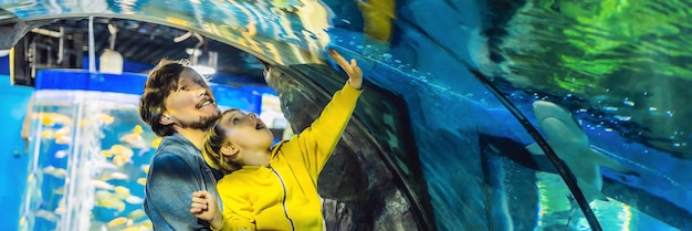 Vater und Sohn schauen sich die Fische im Aquarium im Ozeanarium-Banner-Langformat an