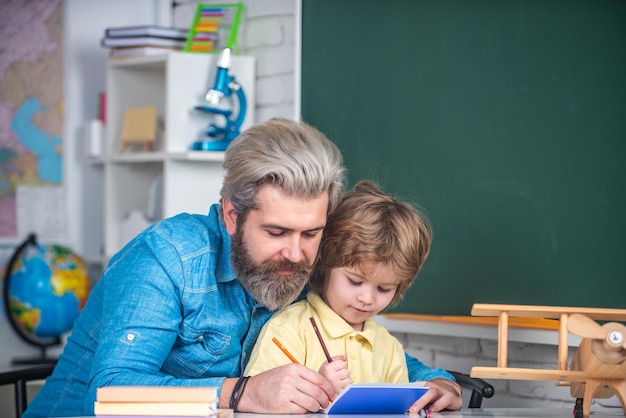 Vater und Sohn schulen zusammen Schüler lernen Buchstaben und Zahlen Lehrer und Schüler private Kinder