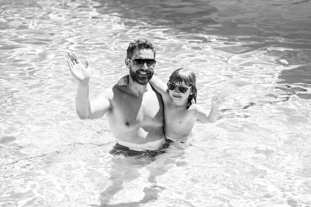 Vater und Sohn schwimmen im Pool Sommer Familie Kind mit Papa spielt im Schwimmbad Aquapark Vater und Sohn Freizeit