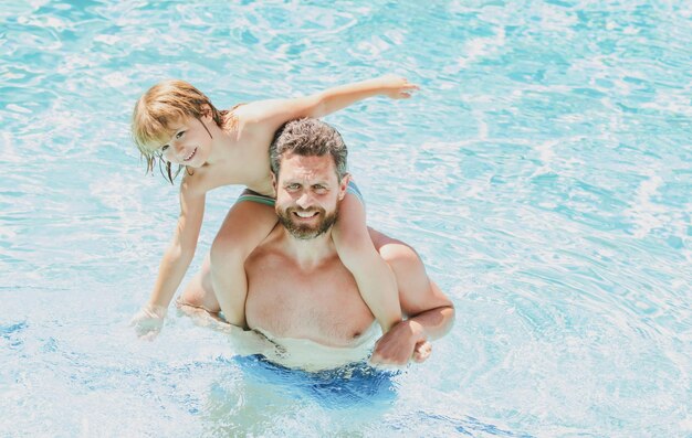 Vater und Sohn schwimmen im Pool Sommerfamilie Lustiger Vater und Sohn im Pool Sommerferien Familienwochenende