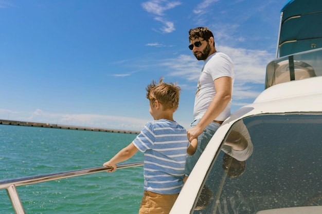 Vater und Sohn segeln auf einer Yacht und genießen den Blick auf das Meer