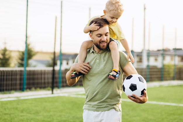 Vater und Sohn spielen auf dem Fußballfeld Fußball