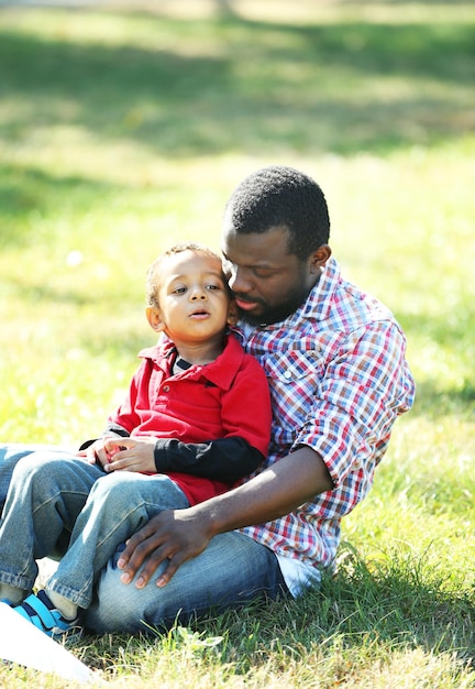 Vater und Sohn spielen auf dem Rasen im Park