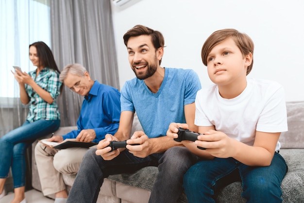 Vater und Sohn spielen auf der Spielkonsole.