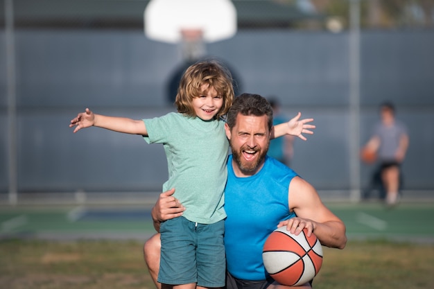 Vater und Sohn spielen Basketball. Konzept des gesunden Urlaubs und der Familienaktivität.