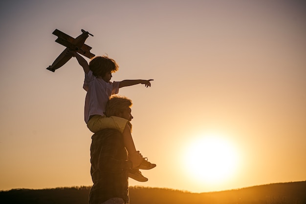 Vater und Sohn spielen draußen Vater und Sohn spielen im Park bei Sonnenuntergang Kindheitserinnerungen