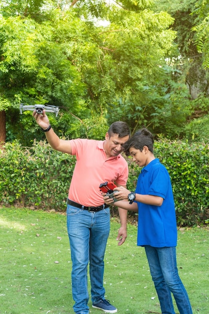 Vater und Sohn spielen mit Drohne im Garten