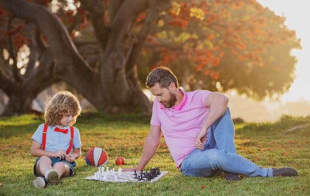 Vater und Sohn spielen Schach und verbringen Zeit miteinander im Park Kinderschachschule