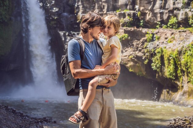 Vater und Sohn Touristen auf dem Hintergrund eines Wasserfalls Reisen mit Kindern Konzept Was mit Kindern zu tun ist Kinderfreundlicher Ort