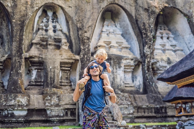 Vater und Sohn vor dem Hintergrund von Gunung Kawi. Alt geschnitzt im Steintempel mit Königsgräbern. Bali, Indonesien. Reisen mit Kinderkonzept..