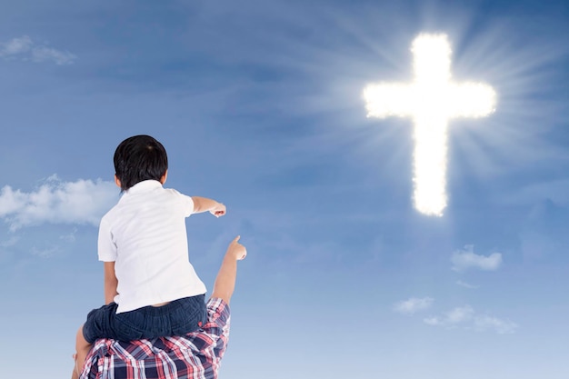 Vater und Sohn zeigen auf das Kreuz
