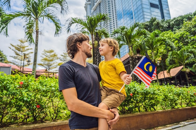 Vater- und Sohnreisende in malaysia mit malaysia-Flagge, die den malaysischen Unabhängigkeitstag und den malaysischen Tag feiert Konzept der Reise nach Malaysia