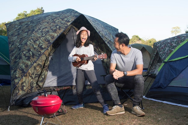 Vater und Tochter am camping spielen Ukulele