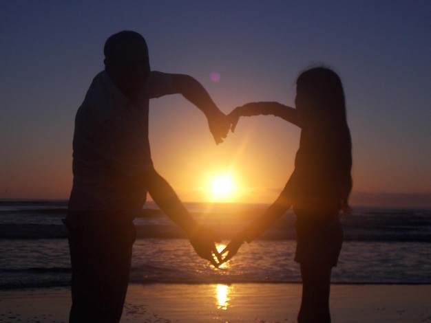 Vater und Tochter am Strand bei Sonnenuntergang