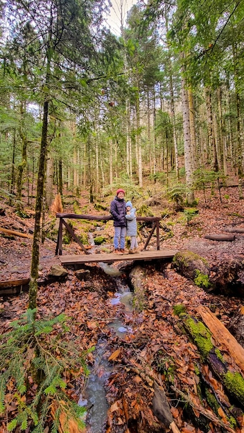 Vater und Tochter auf der Brücke über den Bergfluss