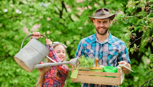 Vater und Tochter auf der Ranch kleines Mädchen und glücklicher Mann Vater Tag der Erde Frühling Dorf Land Ökologie Gießkanne und Schaufel Familienbauernhof Arbeiten im Gewächshaus Florist bei der Arbeit