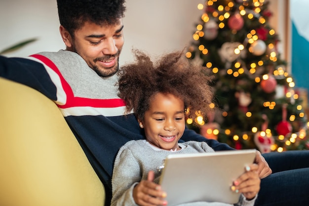 Vater und Tochter benutzen Tablet und haben gemeinsam Spaß