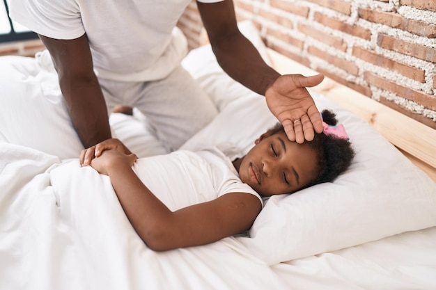 Vater und Tochter berühren sich im Schlafzimmer wegen Fieber