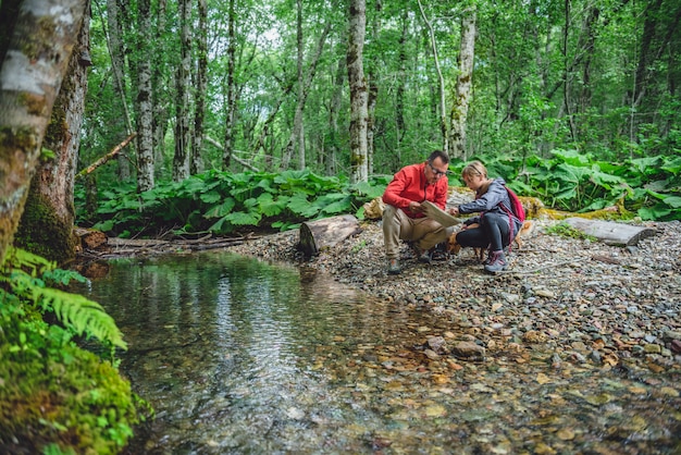 Vater und Tochter, die im Wald wandern und Karte überprüfen