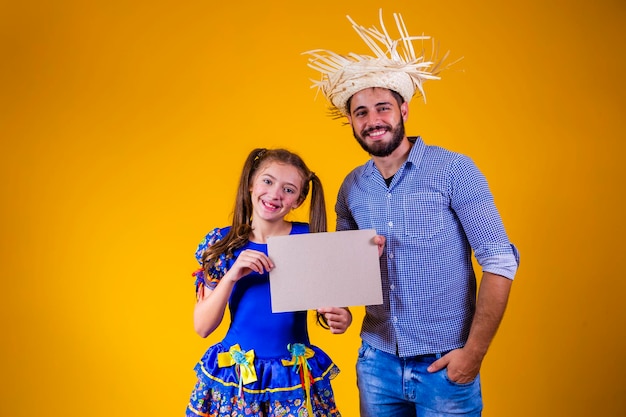 Vater und Tochter gekleidet in Juni-Party-Kleidung mit einem Schild mit Kopierraum