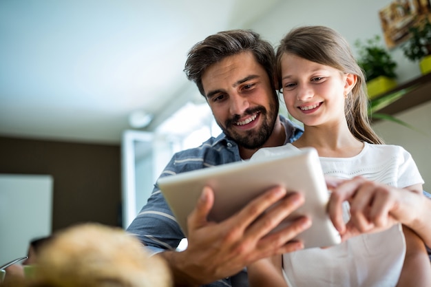 Vater und Tochter mit digitalem Tablet im Wohnzimmer