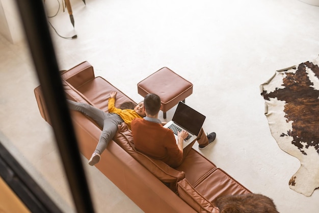 Vater und Tochter mit Laptop zu Hause.