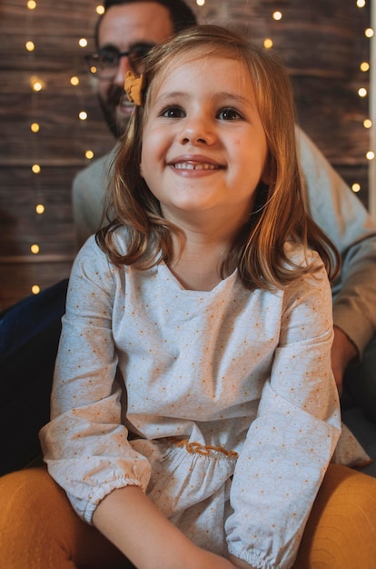 Foto vater und tochter sitzen zu weihnachten zu hause