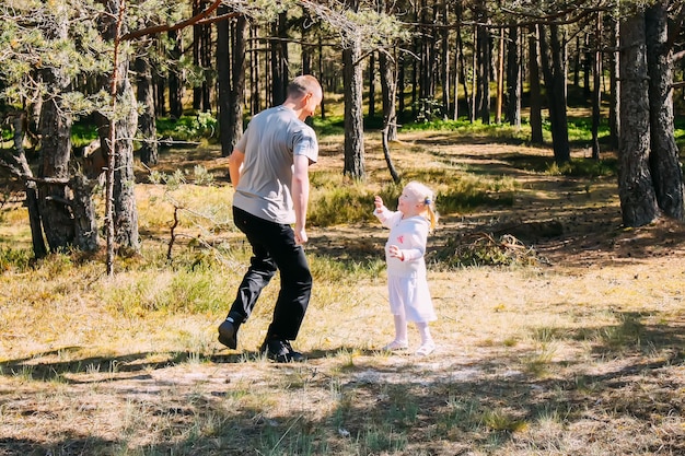 Vater und Tochter spielen in einem Frühlingswald Aktive Menschen amüsieren sich im Freien