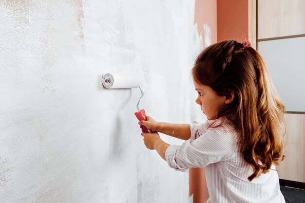 Vater und Tochter streichen die Wand im Raum. Hausrenovierung