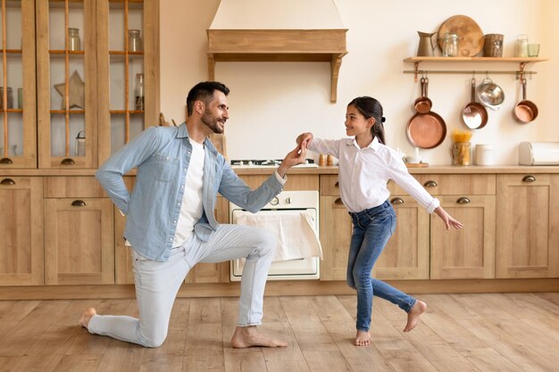 Vater und Tochter tanzen zu Hause fröhlich