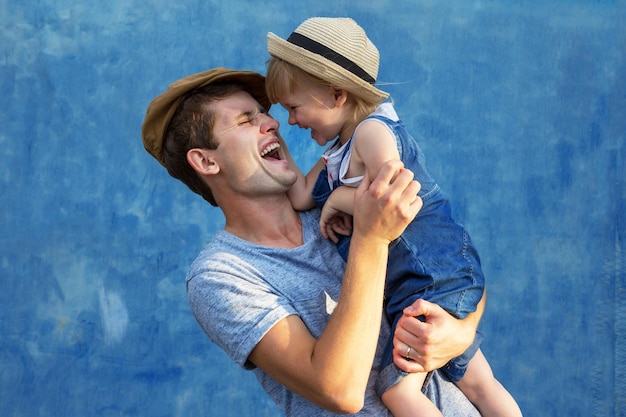 Vater und Tochter umarmen sich auf blauem Hintergrund