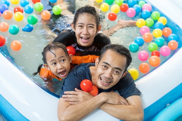 Vater und Töchter spielen in einem Schwimmbad