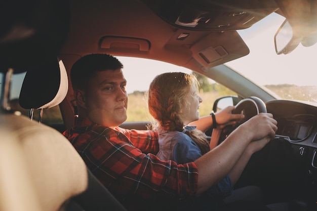 Vater unterrichtet seine Tochter beim Fahren im Auto