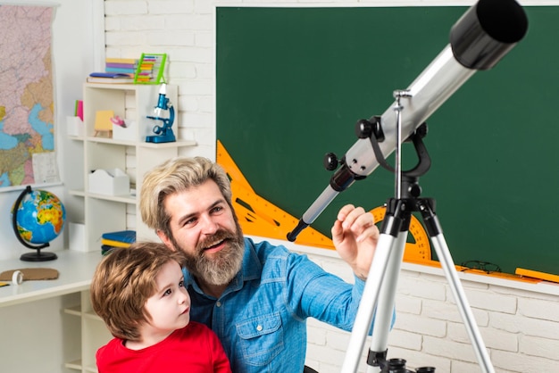 Vater unterrichtet Sohn Glücklicher Schüler beim Unterricht mit Astronomie-Teleskop