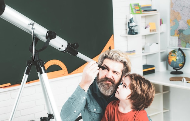 Vater unterrichtet Sohn Kid lernt im Unterricht auf dem Hintergrund der Tafel Glückliche Schulkinder im Unterricht