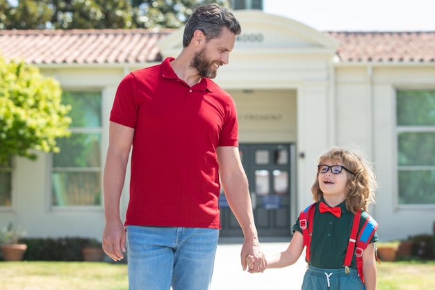 Vater unterstützt und motiviert Sohn Kind geht in die Grundschule Zurück zur Schule und glückliche Zeit