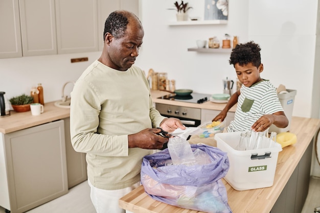 Vater zeigt seinem Sohn, wie er Müll sortiert