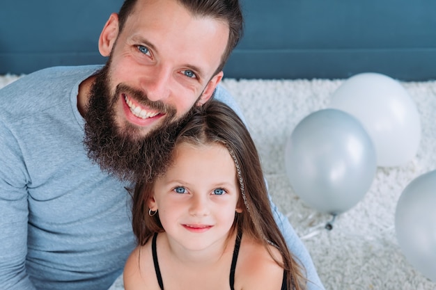 Vaterschaft. Vater-Tochter-Bindung. Liebesausdruck und glückliche Familienbeziehung. Porträt des lächelnden freudigen Vaters, der sein kleines Prinzessinnenmädchen umarmt.