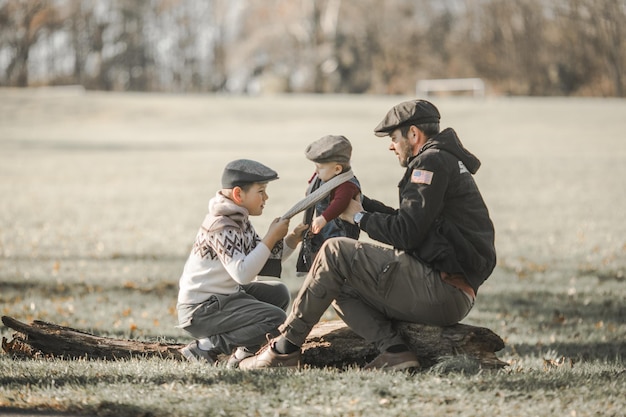 Vatertag Brüder und ihr Vater genießen die Zeit zusammen in der Natur, ein offener, echter Familienmoment.