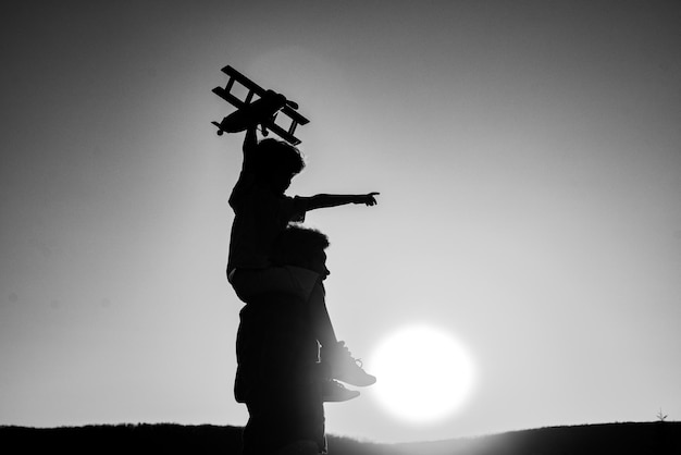 Vatertag Vater und Sohn spielen bei Sonnenuntergang mit Familienzeit zusammen Silhouette